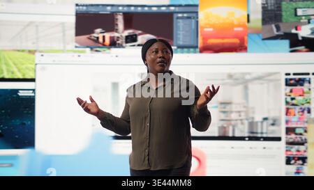 La personne aime regarder la bibliothèque de contenu de service de streaming vidéo divertissant sur le mur multimédia dynamique. Femme afro-américaine vivant le divertissement axé sur le style de vie numérique de l'âge, appareil photo A. Banque D'Images