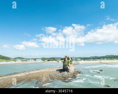 Vues aériennes de la plage de Kkotji à Anmyeondo, montrant les îlots rocheux emblématiques et la côte étendue sous un ciel bleu vif avec de douces vagues océaniques. Banque D'Images