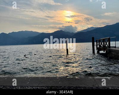 Coucher de soleil paisible sur le lac de Garde avec Jetty Silhouette et Ducks Italy Banque D'Images