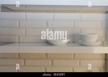 Plats blancs sur étagère de cuisine intérieur minimal de cuisine nettoyer la vaisselle et le concept d'organisation de la maison Banque D'Images