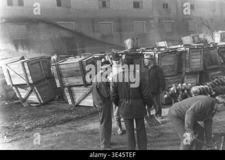 Sloviansk, avril 1989, cour d'usine AIZ. Un groupe de directeurs d'usine portant des vêtements d'extérieur chauds se réunit et discute activement du processus de défrichement du territoire lors d'un événement traditionnel de nettoyage de volontaires de sous-botnik au printemps. Au premier plan, un employé dévoué effectue continuellement un travail manuel lourd avec une pelle. Cette scène dynamique en plein air illustre parfaitement l’effort physique combiné, le travail d’équipe continu et les responsabilités communautaires partagées du collectif de travail dans le Donbass pacifique. Banque D'Images