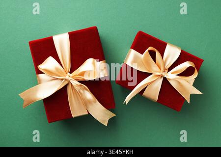 Belles boîtes cadeaux en velours sur fond vert, vue de dessus Banque D'Images