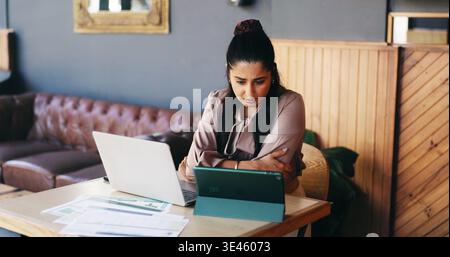 Travail à distance, documents et femme sur la technologie dans le café pour l'examen des finances, la planification budgétaire et la recherche. Café, lecture et personne sur ordinateur avec Banque D'Images