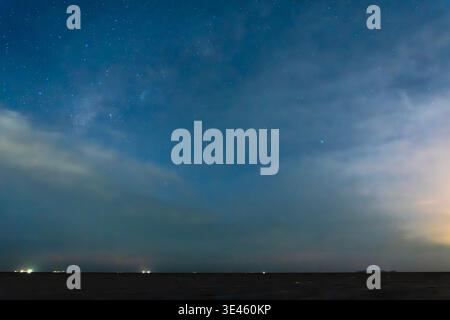 Nuit étoilée avec la galaxie voie lactée près de la mer. Ciel nocturne rempli d'innombrables étoiles et de faible lueur sur un paysage sombre. Nature panoramique Banque D'Images