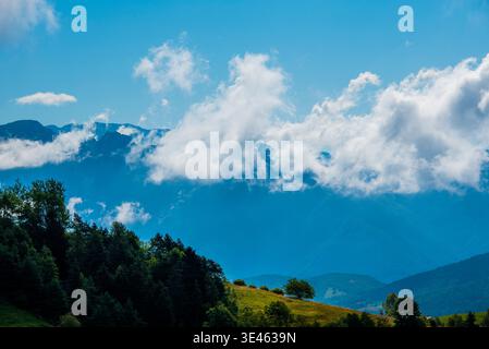 Belle vue sur les sommets du Monte Baldo avec des pâturages verts les bois et les nuages sur le ciel bleu de Monte Altissimo di Nago à trente, Italie Banque D'Images