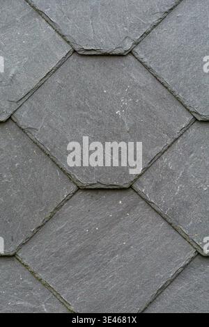 Gros plan de carreaux de pierre d'ardoise gris disposés dans un motif géométrique de diamant. Banque D'Images