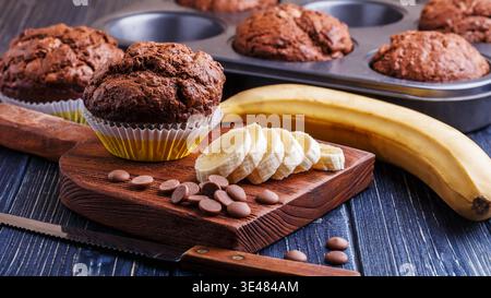 Muffins au chocolat avec banane sur fond sombre, mise au point sélective. Banque D'Images