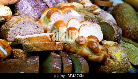 Pains frais exposés dans une boulangerie le matin, montrant différents types de pains et de produits de boulangerie Banque D'Images