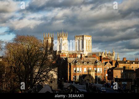 Les tours de l'historique York Minster tour au-dessus des toits des bâtiments environnants, ville de York, Angleterre. Banque D'Images