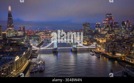 Londres, le Tower Bridge et la City of London la nuit, avec des monuments et des gratte-ciel illuminés créant une ligne d'horizon dramatique de Londres. Banque D'Images