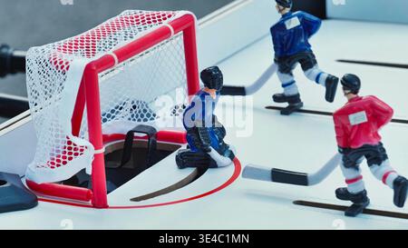 Jeu de hockey de table avec joueurs miniatures et gardien de but devant le filet. Banque D'Images