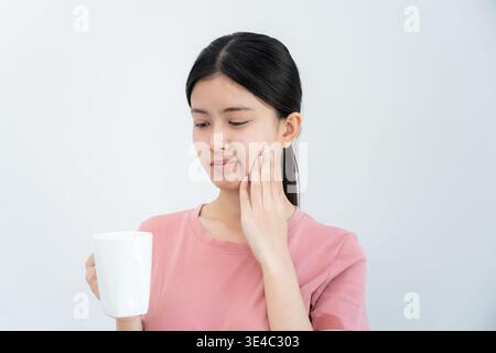 Femme asiatique sentir les dents sensibles après avoir bu chaud, femelle souffrent dent, problèmes de carie, soins dentaires, extraction dentaire, problème de décomposition, mauvaise haleine, GI Banque D'Images