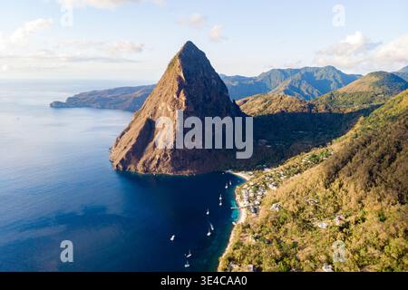 Explorez la beauté à couper le souffle de Sainte-Lucie avec les emblématiques Pitons debout au-dessus de la mer des Caraïbes calme. Ce paysage serein capture l'essence du voyage de luxe et de l'aventure tropicale. Banque D'Images