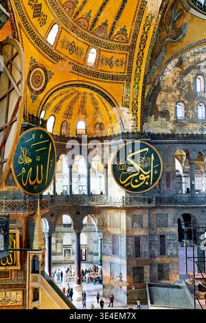 Les visiteurs explorent la Grande Mosquée Sainte-Sophie à Istanbul. La grande architecture présente de grands dômes et des motifs ornés. Banque D'Images