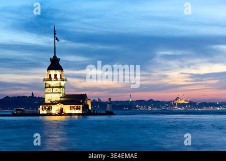 Le coucher du soleil illumine Maiden's Tower sur le Bosphore à Istanbul. Le ciel montre des couleurs chaudes et la tour se tient haute contre l'eau. Banque D'Images