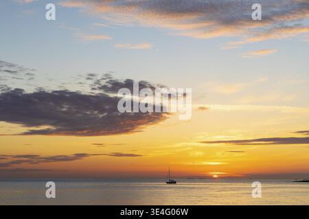 Petit bateau devant le coucher du soleil sur la mer du Nord avec archipel sur la côte ouest près de Lerkil, Hallands laen, Suède Banque D'Images