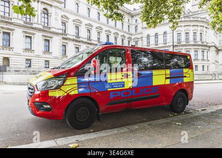 Une fourgonnette de la police métropolitaine avec des marques distinctives rouges, jaunes et bleues garée dans une rue. Londres, Royaume-Uni, 10 août 2024 Banque D'Images