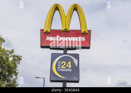 Panneau de McDonalds en bordure de route avec les emblématiques Golden Arches et le panneau 24 heures sur 24. Londres, Royaume-Uni, 14 juillet 2024 Banque D'Images