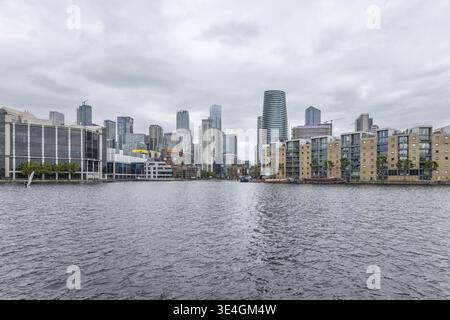 Une vue panoramique sur les gratte-ciel de London Canary Wharf et les gratte-ciel du quartier financier se reflètent dans l'eau sous un ciel couvert. Londres, Royaume-Uni, 9 Ju Banque D'Images