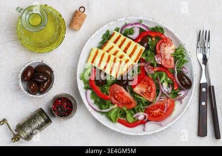 Nourriture, délicieuse salade avec fromage halloumi grillé, laitue, tomates, poivrons, oignons rouges, olives Kalamata, huile d'olive, épices. Cui méditerranéen Banque D'Images