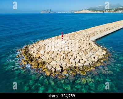 Vue aérienne du brise-lames de Moraira et du petit phare sur la mer Méditerranée, Alicante, Costa Blanca. Eau d'été claire, jetée rocheuse et tranquille Banque D'Images