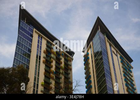 Une photo en bas-angle de deux gratte-ciel modernes avec des surplombs de toit triangulaires pointus distinctifs. Les bâtiments disposent de murs-rideaux en verre et verticaux Banque D'Images