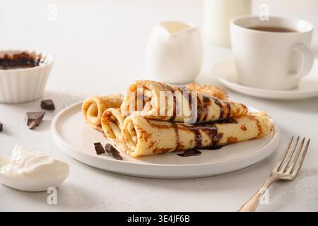 Crêpes fines avec crème aigre et garniture au chocolat. Shrovetide. Petit déjeuner traditionnel russe. Gros plan. Banque D'Images