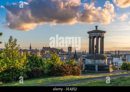 Le monument Dugald Stewart sur Calton Hill offre une vue panoramique sur les gratte-ciel historiques d'Édimbourg, avec le château, la tour de l'horloge et les flèches baignés de chaleur Banque D'Images