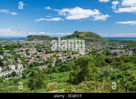 Vue panoramique sur Édimbourg depuis Blackford Hill montrant Salisbury Crags et Arthur's Seat s'élevant au-dessus de quartiers résidentiels et de parcs verdoyants Banque D'Images