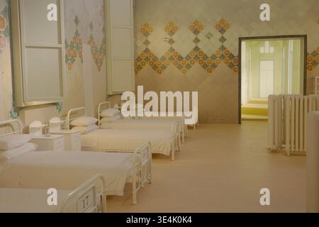 Hôpital restauré du début du XXe siècle avec lits en fer blanc et carreaux de céramique décoratifs à motif losanges à Recinte Modernista de Sant Pau Banque D'Images
