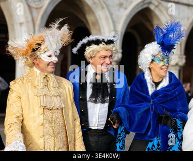 Venise, Italie - 9 février 2026 : trois individus masqués dans des costumes ornés se tiennent ensemble pendant le Carnaval de Venise, mettant en valeur des couleurs riches et Banque D'Images
