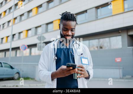 Docteur masculin parlant au téléphone buvant du café Banque D'Images
