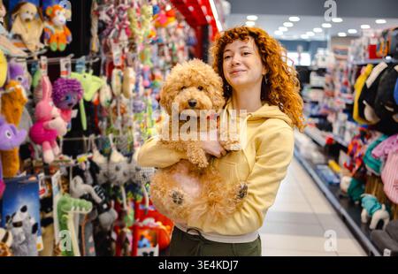 Jeune femme avec caniche dans l'animalerie Banque D'Images
