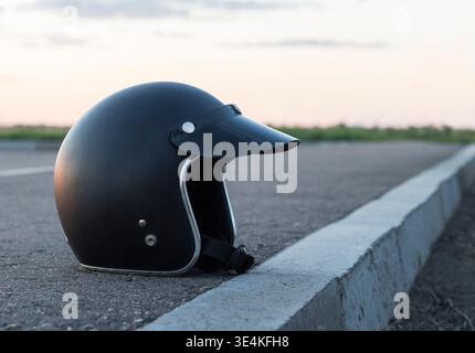 Casque noir pour la protection de la tête et la conduite de moto sur l'asphalte Banque D'Images