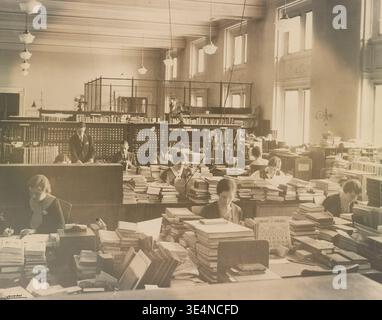 Bibliothécaires classant des livres à la Bibliothèque du Congrès à Washington, D.C. une photographie historique de Louden montrant le personnel organisant et cataloguant des volumes dans une grande salle de lecture, 1933 Banque D'Images
