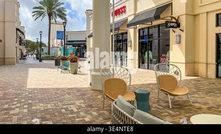 West Palm Beach FL, États-Unis - 05 mars 2026 : le centre commercial extérieur dispose de sièges modernes, de palmiers et de devantures de magasins sous un bleu clair Banque D'Images