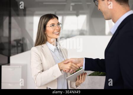 Femme professionnelle serre la main avec un collègue masculin ou un client Banque D'Images