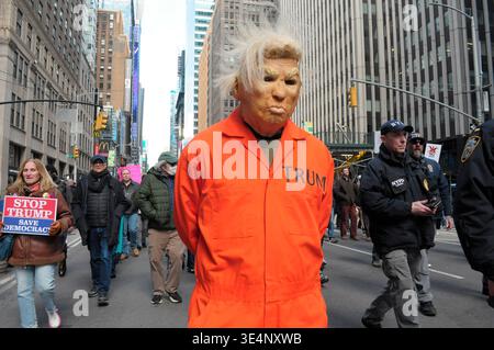New York, États-Unis. 28 mars 2026. Un manifestant portant un masque Donald Trump et une combinaison orange marche lors d’une manifestation Trump. Des manifestants à Manhattan, New York City ont protesté contre Donald Trump dans un rassemblement « No Kings ». Les manifestants ont affirmé que Trump agissait comme s'il avait le pouvoir ultime et contestait le système de freins et contrepoids du gouvernement. Les manifestants ont condamné la guerre des États-Unis et d'Israël contre l'Iran. Immigration et application des douanes ou ICE pour arrêter et expulser des immigrants. Crédit : SOPA images Limited/Alamy Live News Banque D'Images