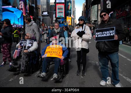 Des manifestants prennent des fauteuils roulants et tiennent des pancartes lors d’une manifestation Trump à Times Square. Des manifestants à Manhattan, New York City ont protesté contre Donald Trump dans un rassemblement « No Kings ». Les manifestants ont affirmé que Trump agissait comme s'il avait le pouvoir ultime et contestait le système de freins et contrepoids du gouvernement. Les manifestants ont condamné la guerre des États-Unis et d'Israël contre l'Iran. Les activistes ont également dénoncé les politiques d'immigration de Trump et l'application de la loi américaine sur l'immigration et les douanes ou ICE pour l'arrestation et la déportation d'immigrants. (Photo Jimin Kim/SOPA images/SIPA USA) Banque D'Images