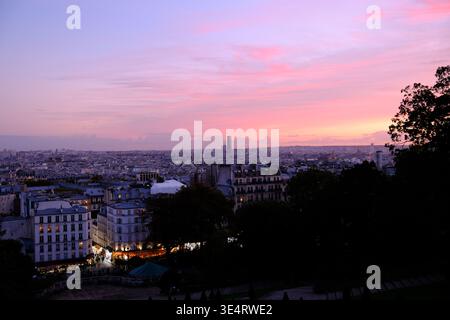 Crépuscule sur la ville de Paris depuis Montmartre, avec une lueur violette illuminant l'horizon Banque D'Images