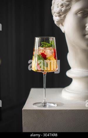 Cocktail avec de la menthe d'agrumes et des baies près de la statue Banque D'Images