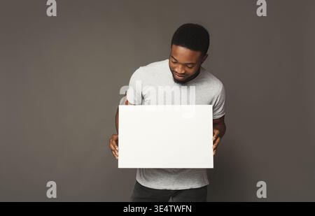 Photo d'un jeune homme afro-américain tenant un tableau blanc blanc Banque D'Images