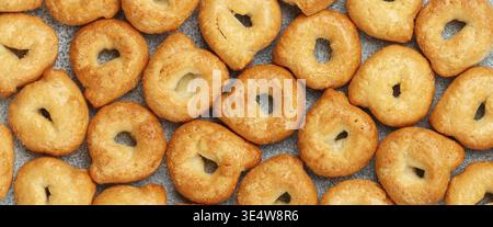 Nourriture, Tarallini-petits bagels italiens traditionnels. Taralli. Gros plan sur un délicieux encas. Fond culinaire. Mise au point sélective, vue de dessus, image longue, banne Banque D'Images