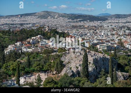 ATHÈNES, GRÈCE - 18 FÉVRIER 2026 : touristes et visiteurs se sont rassemblés sur le plateau rocheux Areopagus surplombant la ville d'Athènes sous un ciel bleu. Banque D'Images