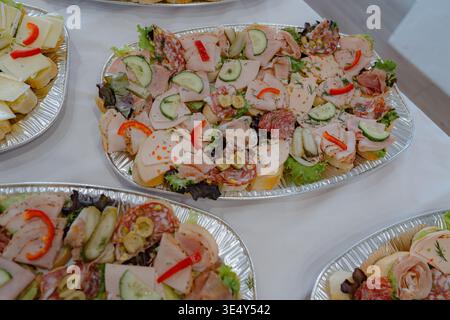 Vue panoramique sur la table du buffet avec assiettes de restauration variées comprenant viandes, fromages et légumes. Parfait pour les événements, les fêtes et les célébrations. Banque D'Images