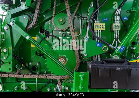 système d'entraînement mécanique vert complexe sur les machines agricoles, avec chaînes à rouleaux en acier, pignons, ressorts et lignes hydrauliques, représentant Banque D'Images