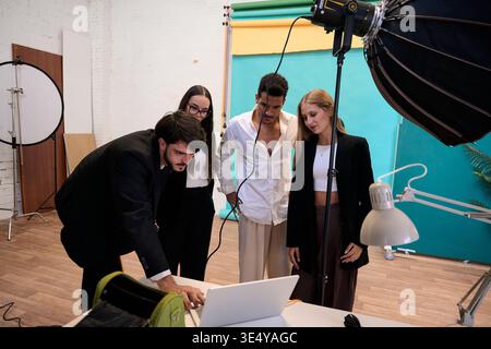Équipe créative examinant les résultats lors d'une séance photo en studio Banque D'Images