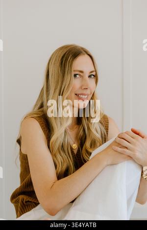 Femme confiante souriant doucement dans un fond neutre Banque D'Images