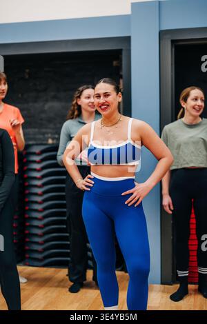 Femme heureuse participant à la classe de groupe de fitness Banque D'Images