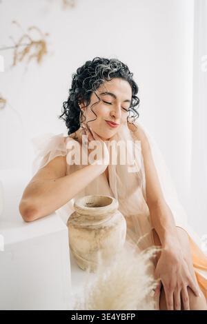 Femme avec les cheveux bouclés se sentant calme et amour de soi Banque D'Images